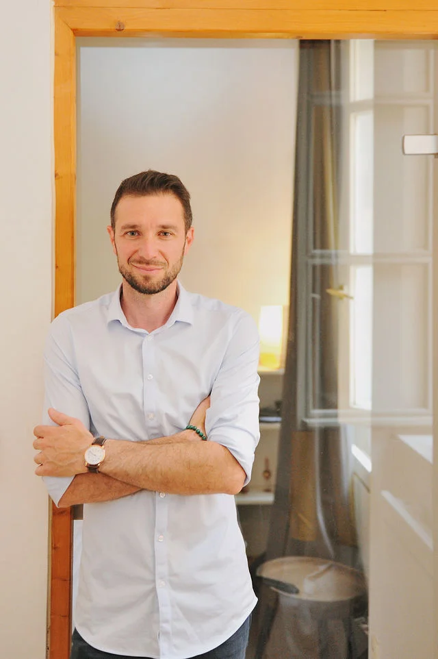 Portrait du psychothérapeute Jean-Luc Sala adossé à un encadrement de porte